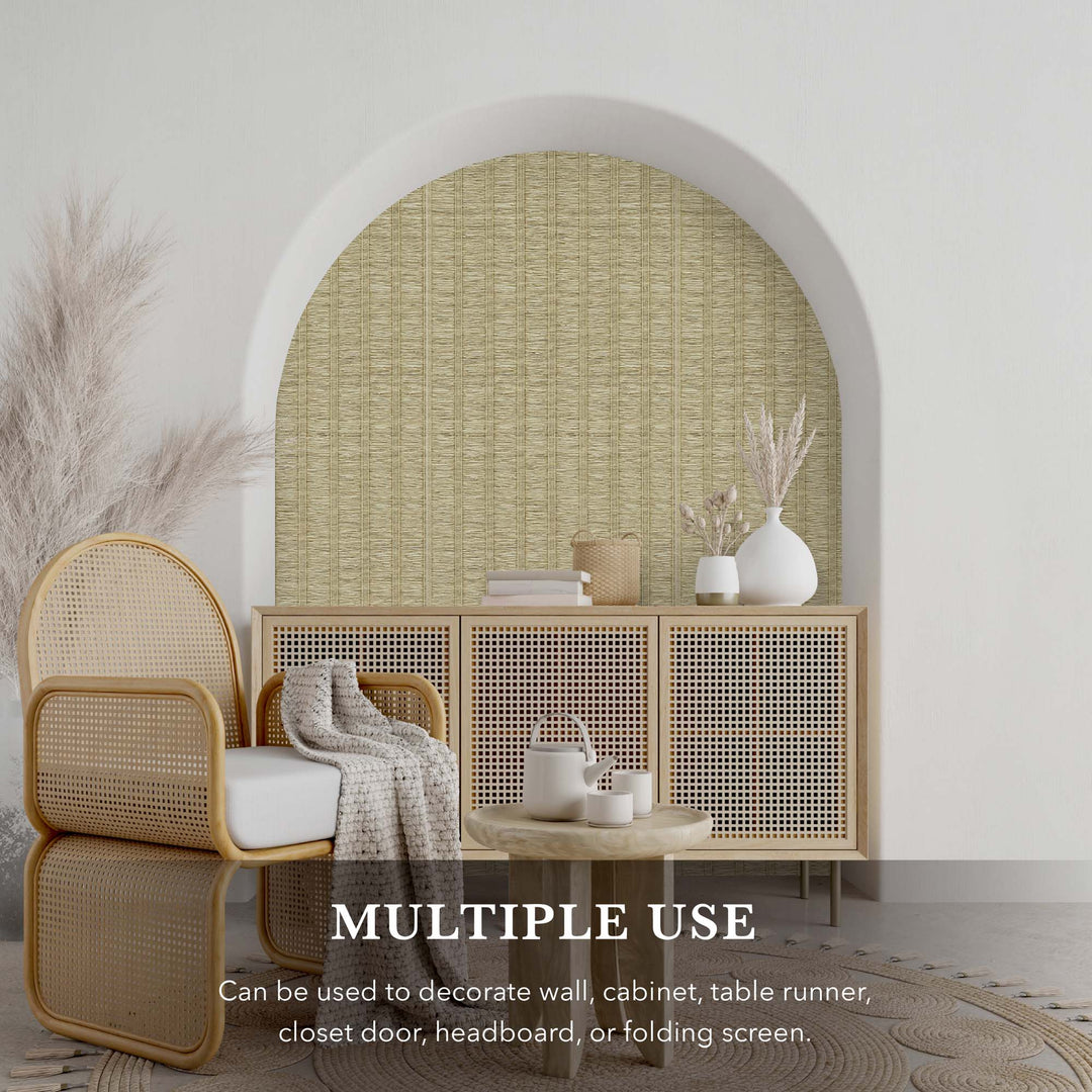 Decorative alcove with light beige textured vertical stripe wallpaper, rattan armchair, woven cabinet, and neutral-toned home decor accents.