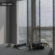 GoDear Design Window blinds filtering light in a room with a table and decor items.