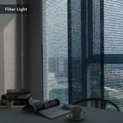 GoDear Design Window with blinds filtering light, table with books and a cup in the foreground