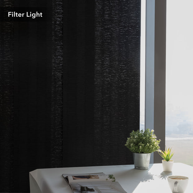 GoDear Design Black textured curtain filtering light in a room with a table and plants.