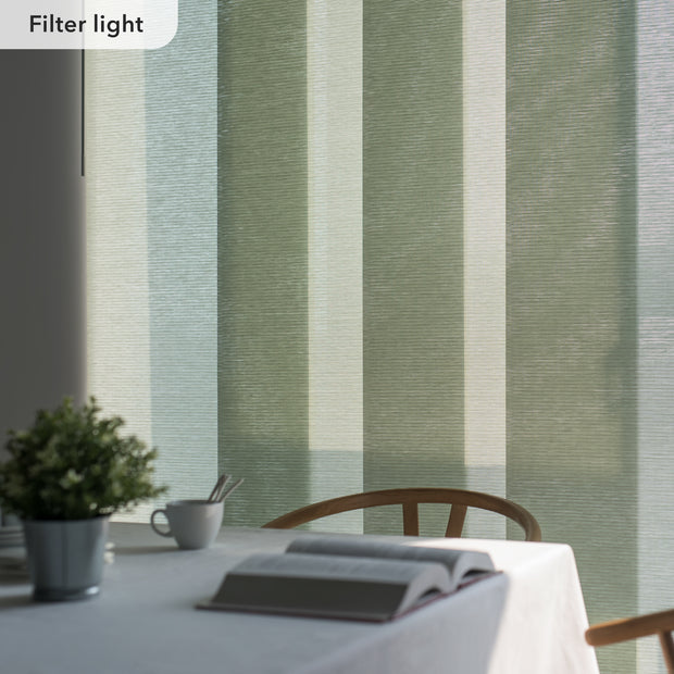 Table setting with a book and cup against a striped green and beige wall.