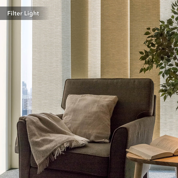 Cozy armchair with a blanket and pillow against a striped wall.