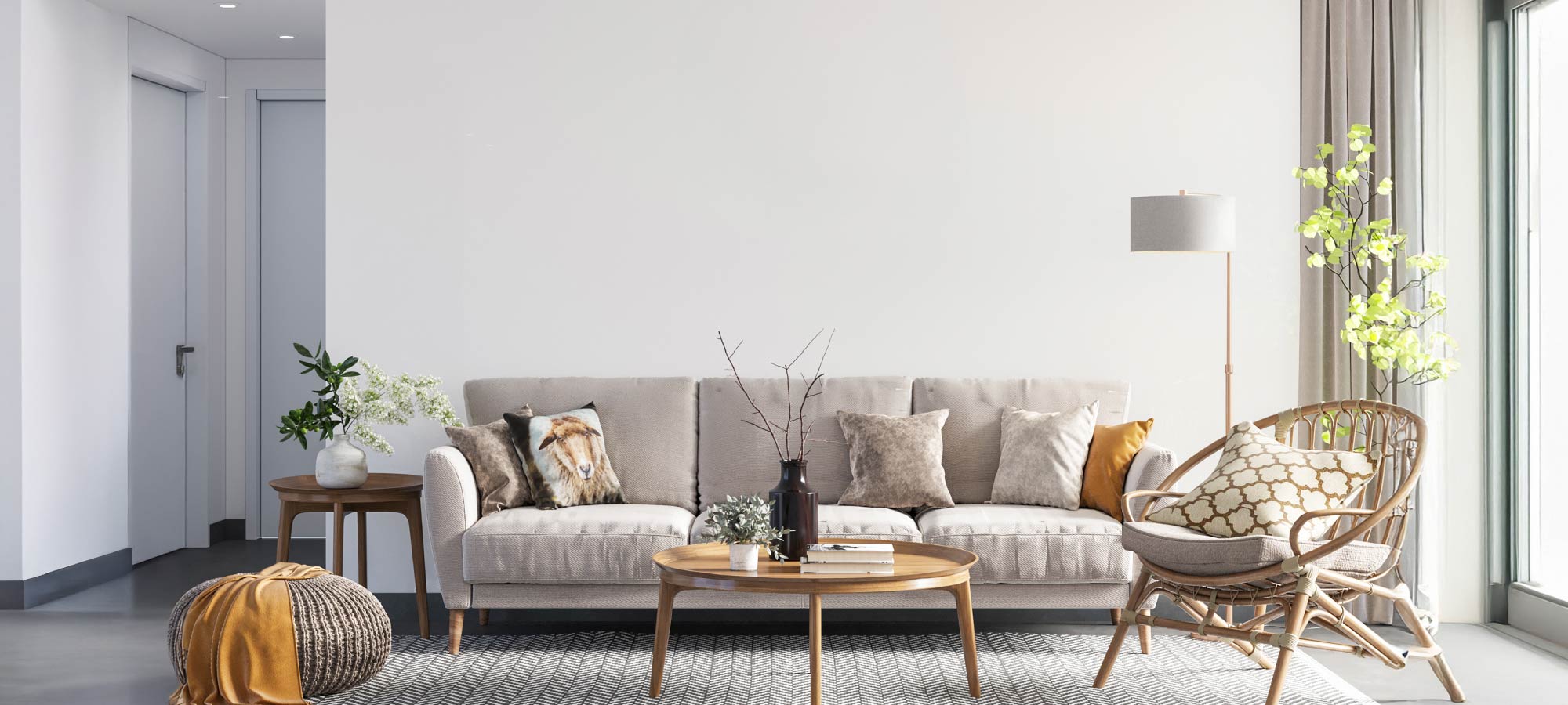 Bright living room with a neutral sofa, patterned cushions, rattan chair, round wooden coffee table, and gray plaid textured wallpaper.