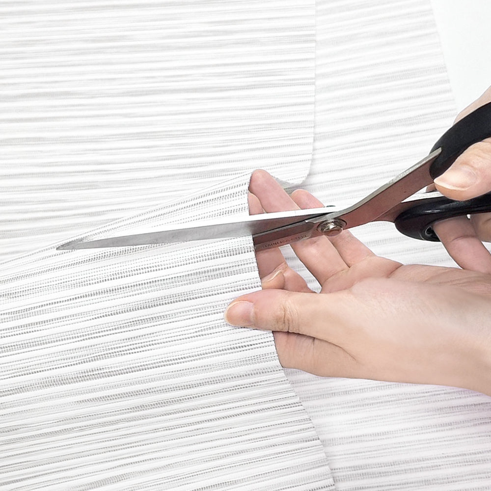 Person cutting white blinds with scissors on a white background