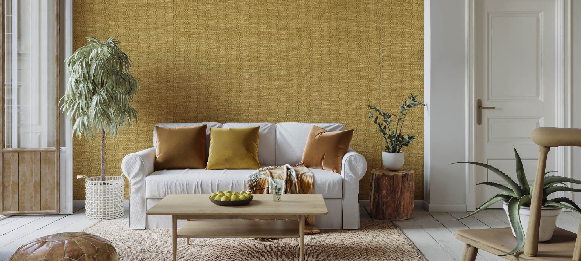 Modern living room interior with white sofa, golden throw pillows, wooden coffee table, potted plants, and textured accent wall.