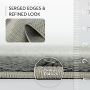 Gray rug with serged edges and refined look, showing pile height measurement.