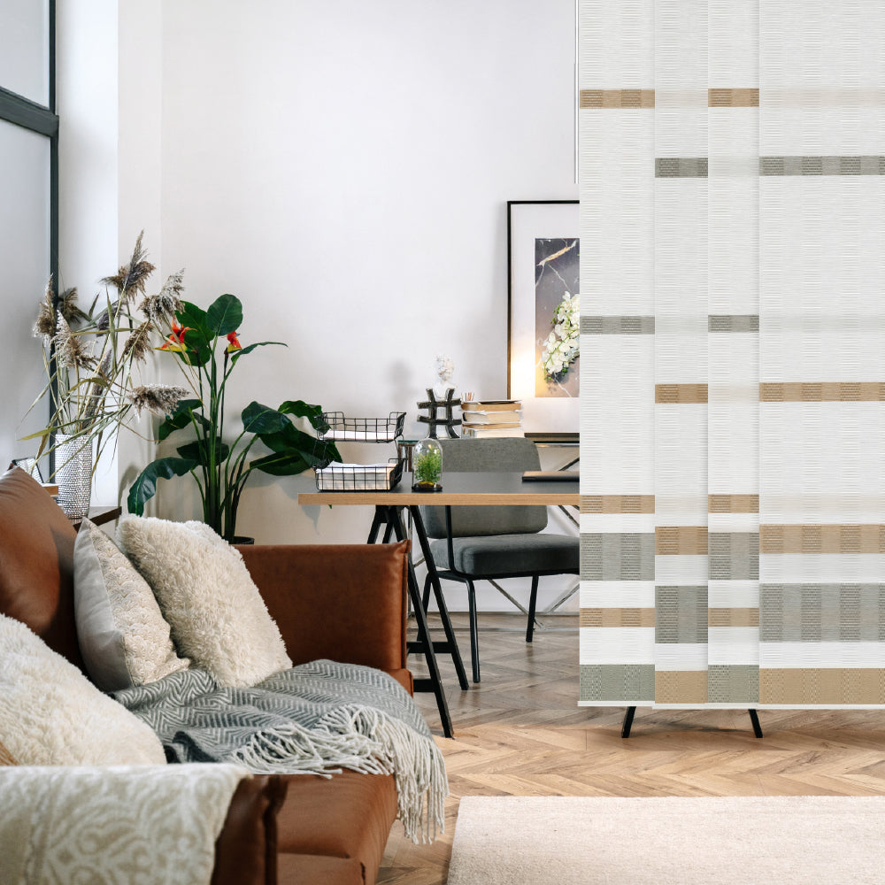 Living room with a sofa, decorative pillows, and a geometric patterned room divider.