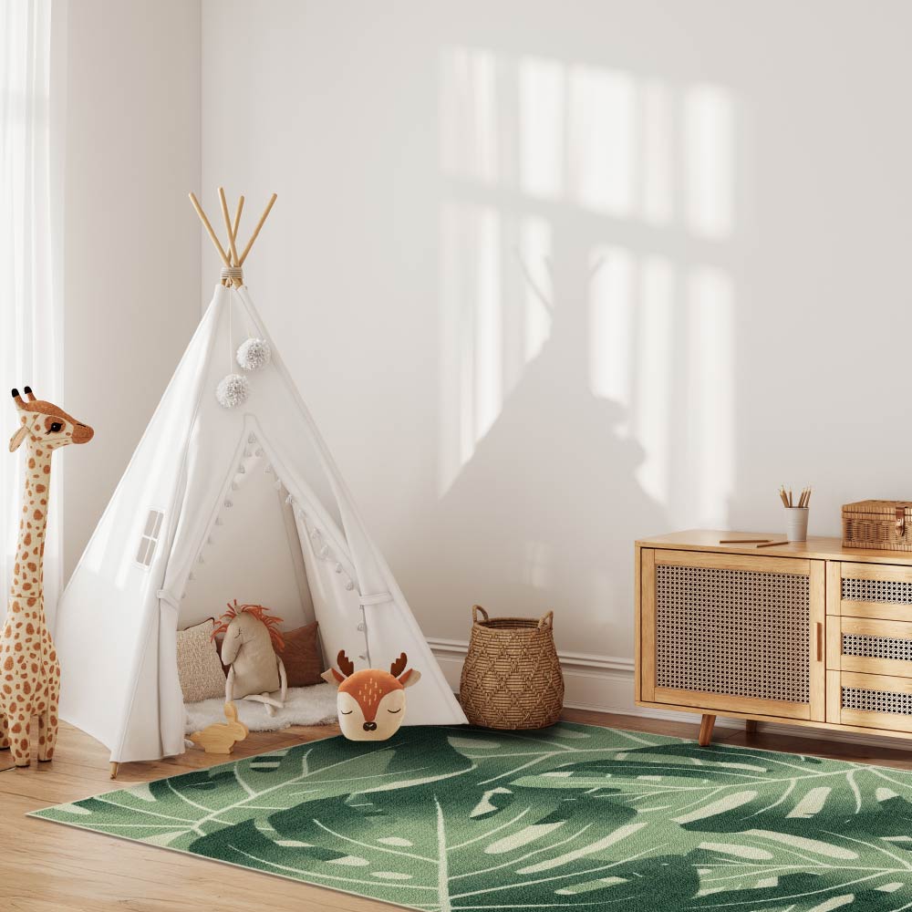 Children's room with a teepee, toys, and a green leaf-patterned rug.