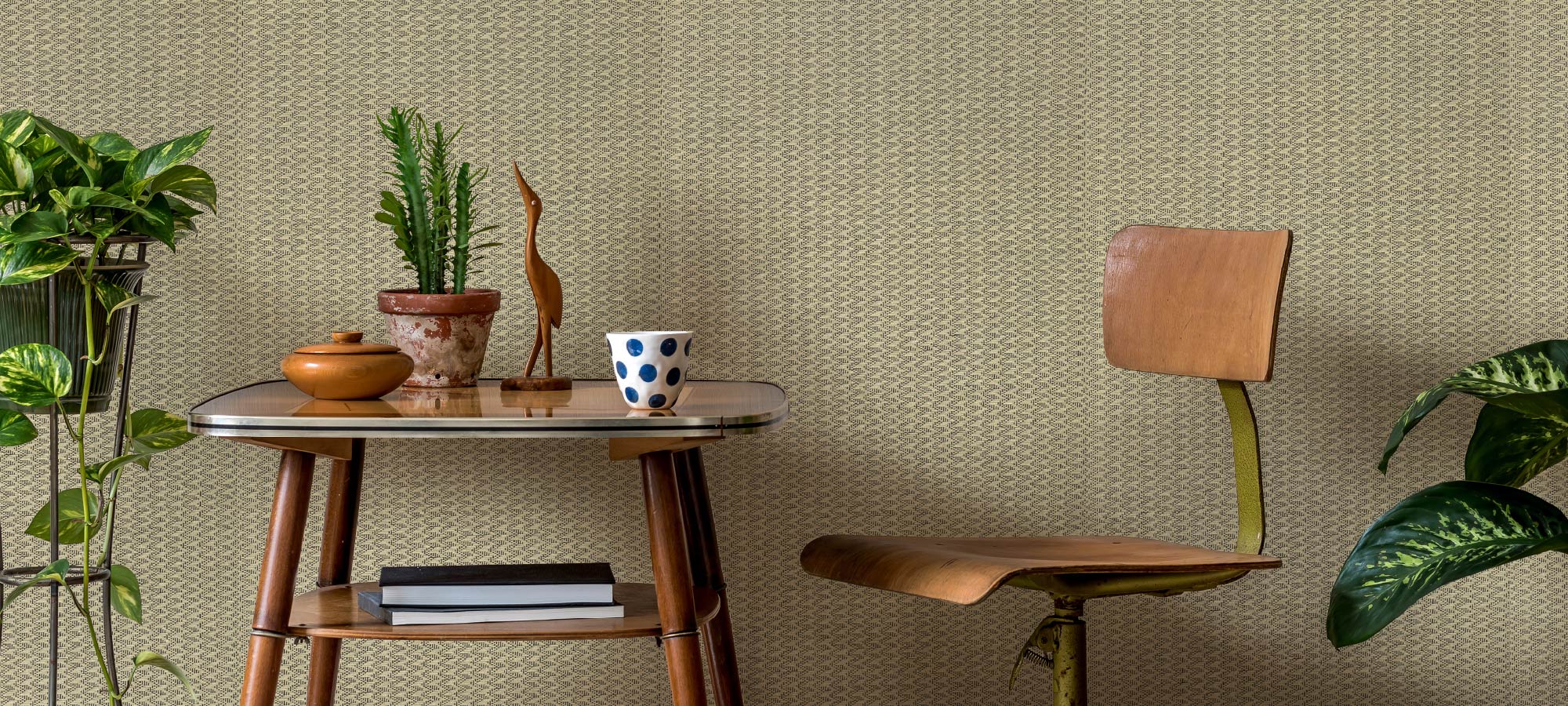 GoDear Design_Small wooden table with a chair against a textured wall with plants around.
