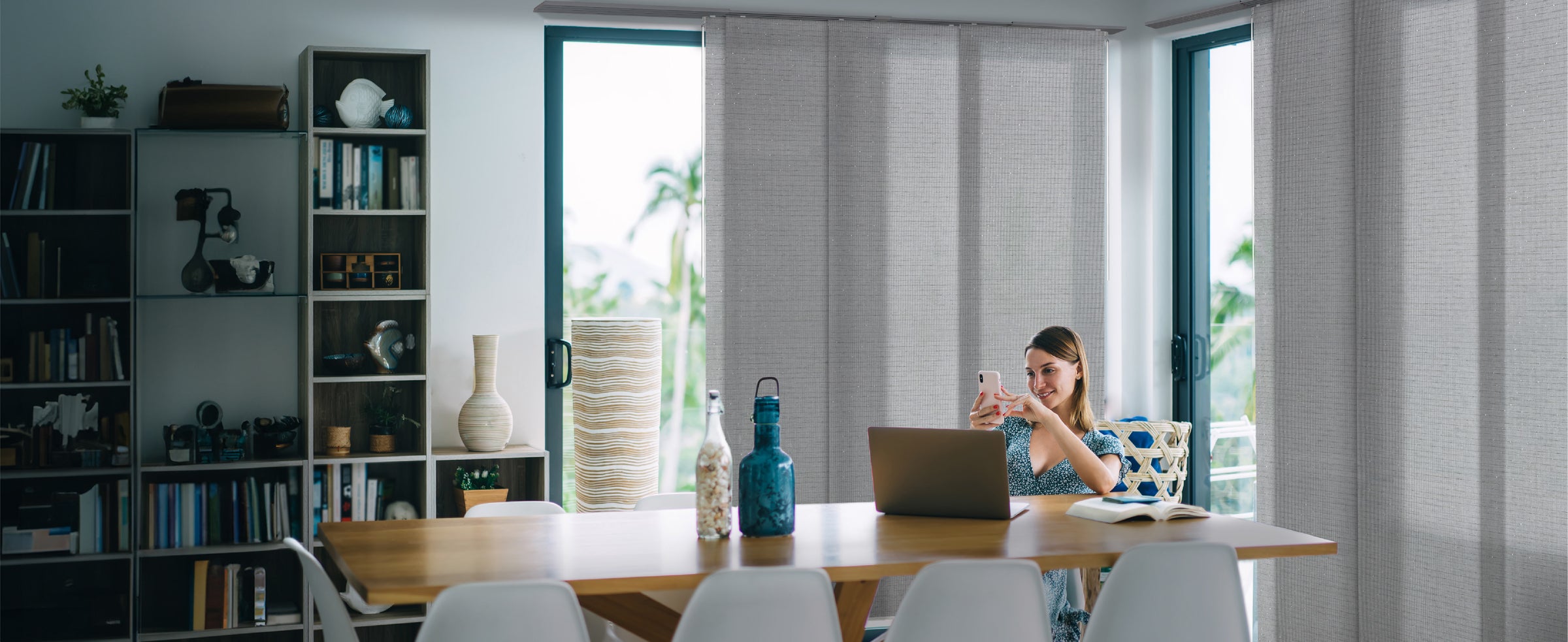 GoDear Design_Woman using a laptop at a table with a modern interior setting