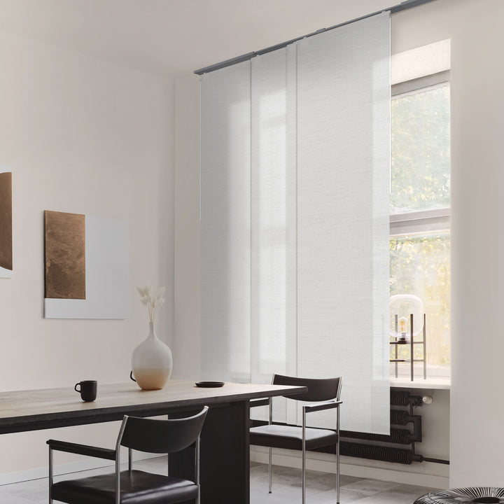 Modern interior with a dining table and chairs near a large window.