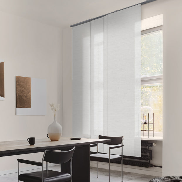 Modern interior with a dining table and chairs near a large window.